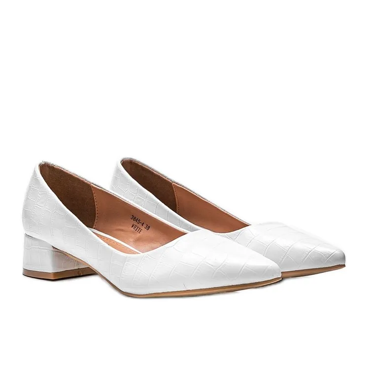 Witte pumps op een baksteen in Hallie's slangenleerpatroon